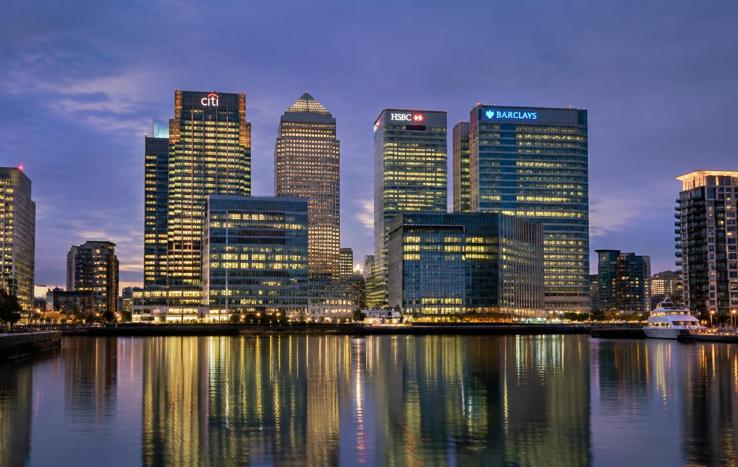 Canary Wharf skyline reflected in the dock at dusk in London